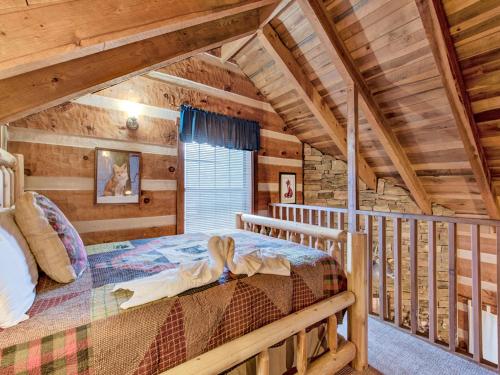 1 dormitorio con 1 cama en una cabaña de madera en Fox Den, 2 Bedrooms, Sleeps 4, Whirlpool Tub, Deck, Yard, Hot Tub, en Gatlinburg