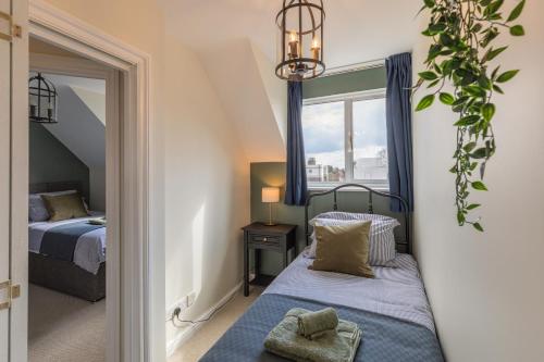 a small bedroom with two beds and a window at 4 Bed City House with Private Garden and Parking in Winchester