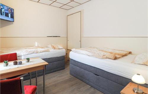 duas camas num quarto com mesa e cadeiras em Awesome Home In Blankenburg Harz With Kitchen em Blankenburg