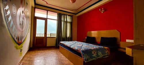 a bedroom with a bed and a red wall at La Vaca India Manali in Manāli