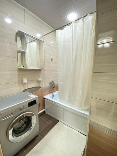een wasmachine in een badkamer met een douche bij Goktash in Bisjkek