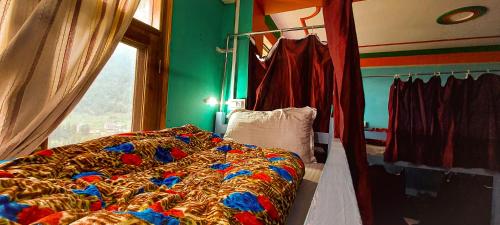 a bedroom with a bed and a window at La Vaca India Manali in Manāli