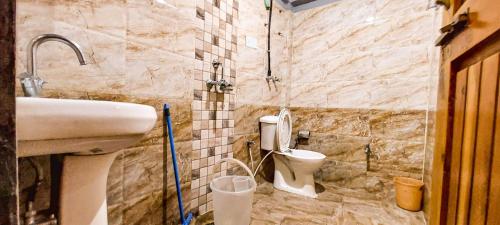 un bagno con lavandino e WC di La Vaca India Manali a Manāli