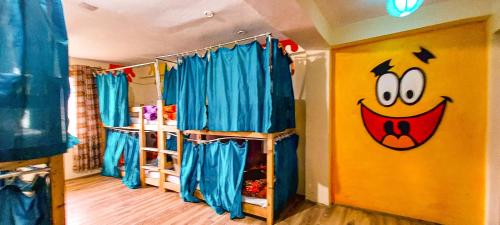 a room with two bunk beds and a face on the wall at La Vaca India Manali in Manāli