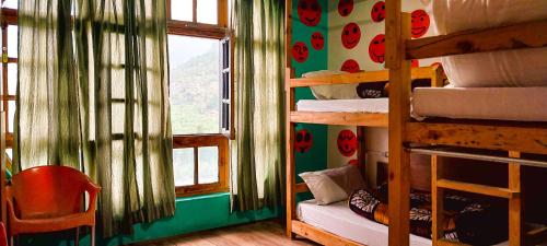 a room with a bunk bed with a window at La Vaca India Manali in Manāli