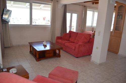 a living room with two red couches and a coffee table at Anastasia Apartment in Zakynthos Town