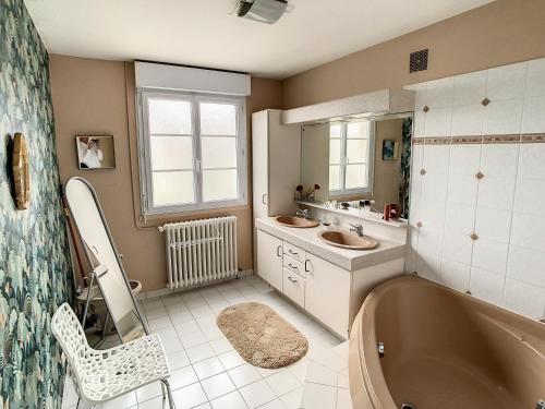 łazienka z wanną, 2 umywalkami i wanną w obiekcie Maison de charme proche centre ville w mieście Avranches