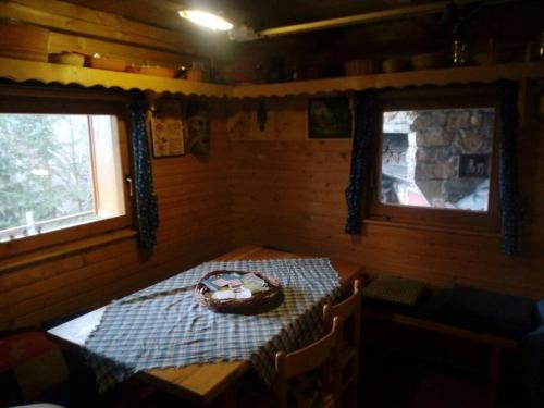 A Cottage in the Alps for hiking, cycling, skiing في جيسينيس: غرفة مع طاولة في كابينة مع نافذتين