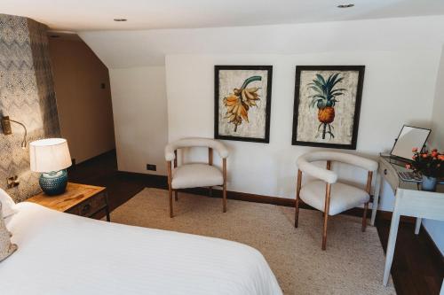 a bedroom with a bed and two chairs and a desk at Finch's Arms in Oakham
