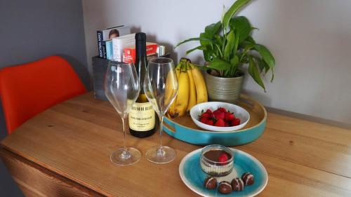 a table with two wine glasses and a bowl of fruit at The Inn Keeper in Cranswick