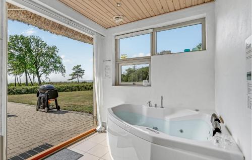 Skødshoved StrandにあるBeautiful Home In Knebel With 3 Bedrooms, Sauna And Wifiの白いバスルーム(バスタブ付)、窓が備わります。