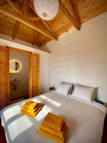 a bedroom with a white bed with yellow towels on it at Lichada Villas in Likhás