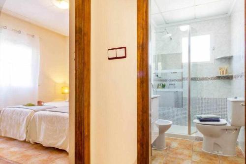 a bedroom with a bed and a bathroom with a toilet at Bungalow Pink Torrevista in Torrevieja