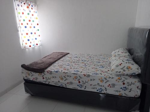 Ce petit lit se trouve dans une chambre dotée d'un couvre-lit. dans l'établissement KENARI P25 HOMESTAY, à Purwokerto