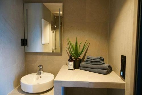 a bathroom with a sink and a toilet and a mirror at Seafront appartment Henningsvær in Henningsvær