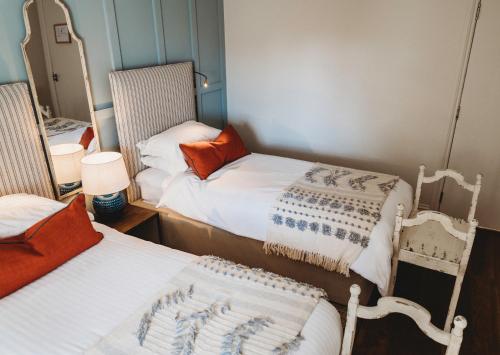 a small room with two beds and two chairs at Finch's Arms in Oakham