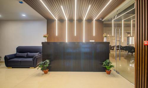 a lobby with a blue couch and a table at Treebo De Alphabet Kondapur in Hyderabad