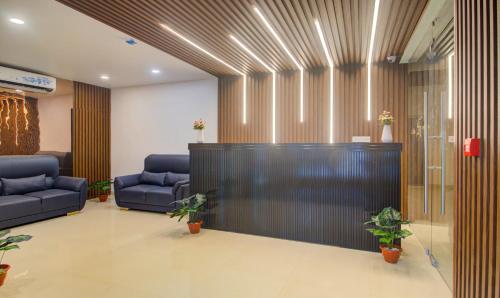 a lobby with two blue couches and a reception desk at Treebo De Alphabet Kondapur in Hyderabad