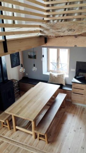 une grande table en bois dans une pièce avec mezzanine dans l'établissement Maison Aux portes d'Emparis, à Mizoën