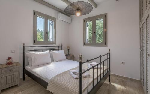 a bedroom with a bed and two windows at Happy Babi in Adamantas