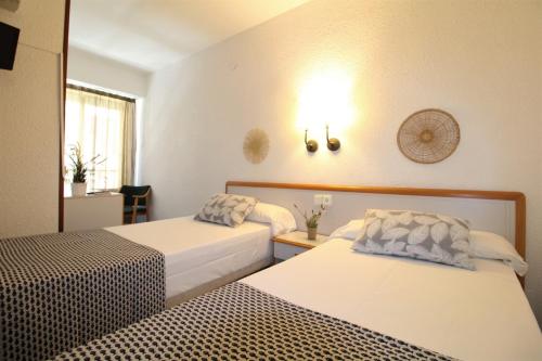 a hotel room with two beds and a window at Hotel Canada in Benicàssim