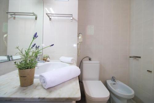 a bathroom with a tub and a toilet and a sink at Hotel Canada in Benicàssim