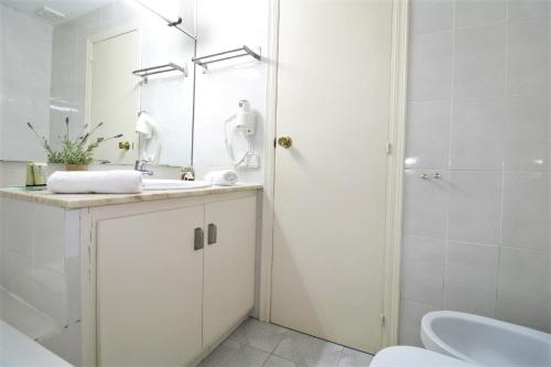 a white bathroom with a sink and a shower at Hotel Canada in Benicàssim