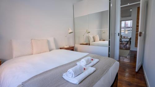 リスボンにあるThe Graça Apartmentのベッドルーム1室(白いベッド1台、タオル付)