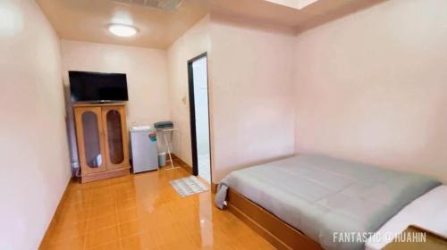 a small bedroom with a bed and a tv at SOLEIL HAUS - Huahin in Hua Hin