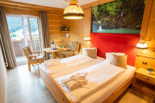 a bedroom with a large bed and a table at Hotel Sonne in Wildhaus