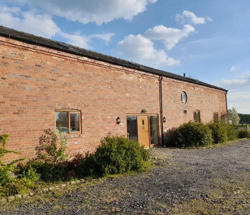 an old brick building with a door on the side at Mile House Barn Bed & Breakfast in Nantwich
