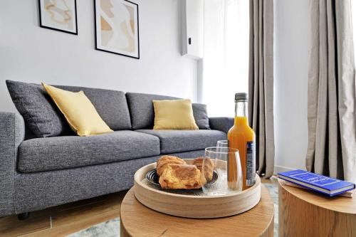 un salon avec un canapé et une table avec une assiette de nourriture dans l'établissement Welcoming apartment - 1BR-4P - Sacré-Cœur, à Paris
