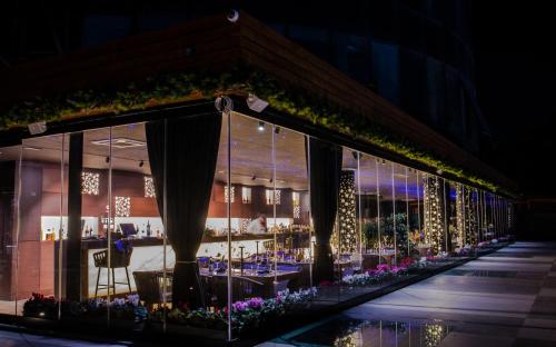 a restaurant with a long window display at night at Arka Art Hotel in Tirana