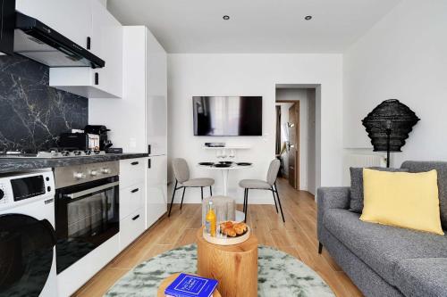 une cuisine et un salon avec un canapé et une table dans l'établissement Welcoming apartment - 1BR-4P - Sacré-Cœur, à Paris
