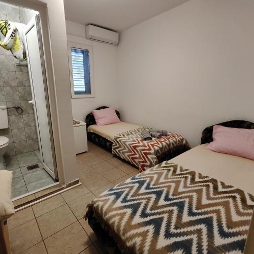 a room with two beds and a shower and a bathroom at Real Apartments in Budva