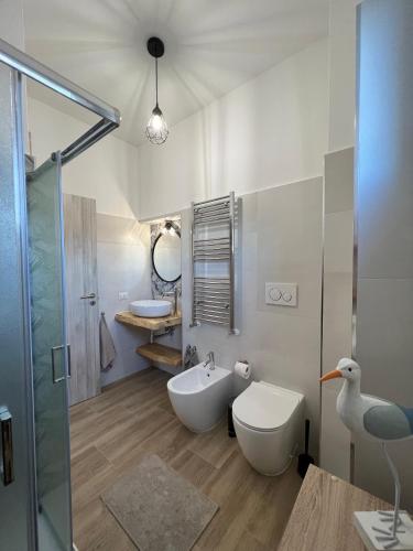 a bathroom with a toilet and a tub and a sink at Waikiki House in Passoscuro