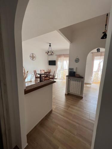 a kitchen and living room with a wooden floor at Waikiki House in Passoscuro