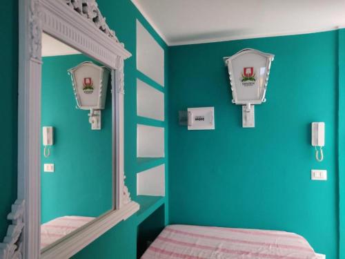 1 dormitorio con espejo y pared verde en Affitto Breve Short Rent Few hours en Catania