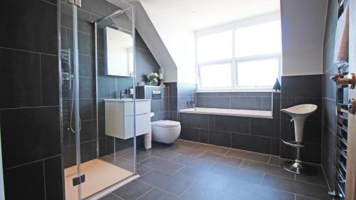 a bathroom with a shower and a toilet and a sink at Sea front luxury apartment with sea views in Felixstowe
