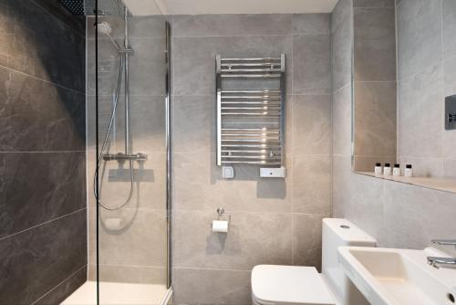 a bathroom with a shower and a toilet and a sink at The King's Head in Thirlmere