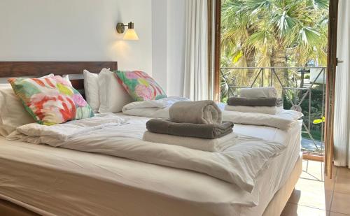 Una gran cama blanca con toallas encima. en Beachhouse 2min to the sea with pool & wonderful garden, en Calviá