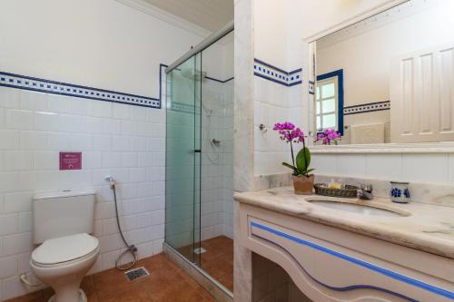 La salle de bains est pourvue de toilettes, d'un lavabo et d'une douche. dans l'établissement Pousada Corsario Paraty, à Parati
