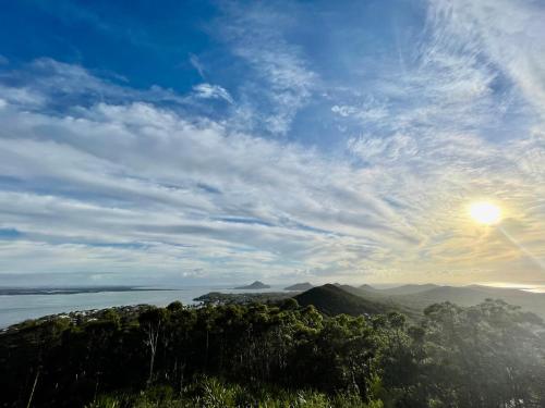 a view of the ocean with the sun in the sky at Port Stephens Home walk to the Beach and Town Centre in Nelson Bay
