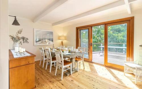 a kitchen and dining room with a table and chairs at Port Stephens Home walk to the Beach and Town Centre in Nelson Bay