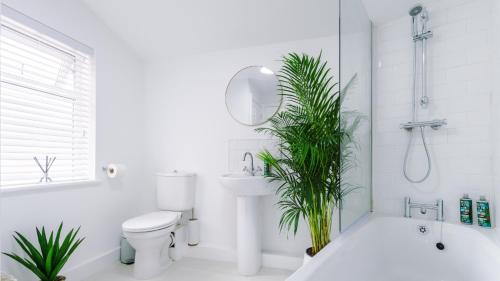 a white bathroom with a toilet and a tub and a sink at Designer apartments for City Breaks in Chester in Chester