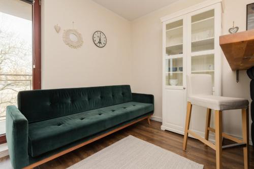 a living room with a green couch and a chair at City Center Apartment with Balcony by Renters in Gdańsk