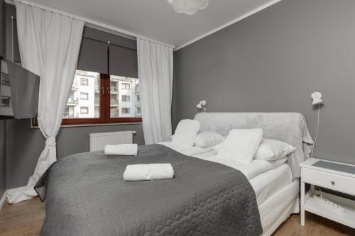 a bedroom with a bed with two towels on it at City Center Apartment with Balcony by Renters in Gdańsk