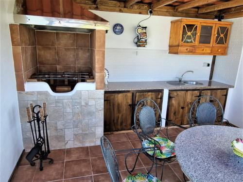 - une cuisine équipée d'une cuisinière ainsi que de tables et de chaises dans l'établissement Finca las Mariposas, à Los Silos