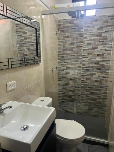 ein Bad mit einem WC, einem Waschbecken und einer Dusche in der Unterkunft Apartamento central en Itagui in Itagüí