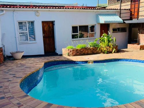 a swimming pool in front of a house at Palm Heaven B&B in East London
